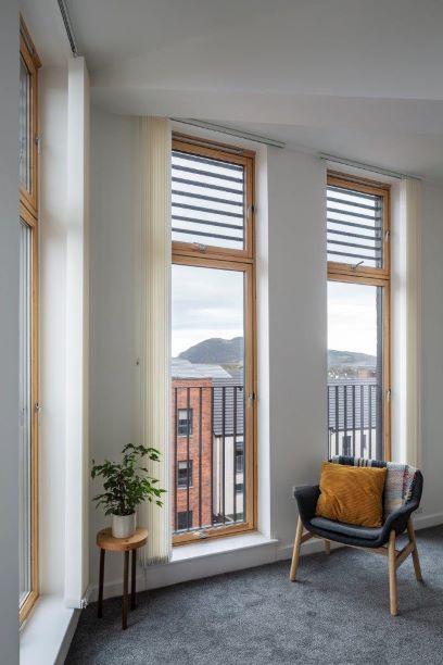 living room with chair facing out large windows