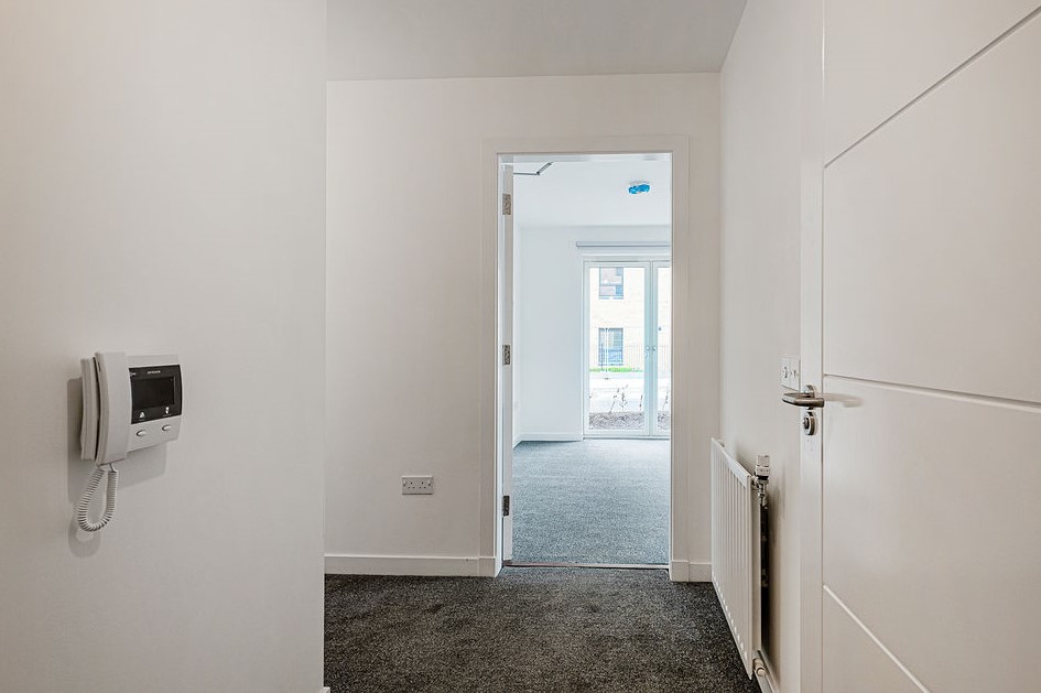 entrance hall inside doorway with white walls and grey carpet